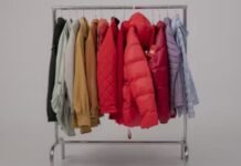 Puffer Jackets: The Ultimate Guide to Cozy, Stylish Winter A clothing rack filled with various winter jackets in different colors, including red puffer jackets, beige coats, and pastel outerwear, arranged neatly against a plain background.Puffer Jackets