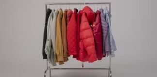 Puffer Jackets: The Ultimate Guide to Cozy, Stylish Winter A clothing rack filled with various winter jackets in different colors, including red puffer jackets, beige coats, and pastel outerwear, arranged neatly against a plain background.Puffer Jackets