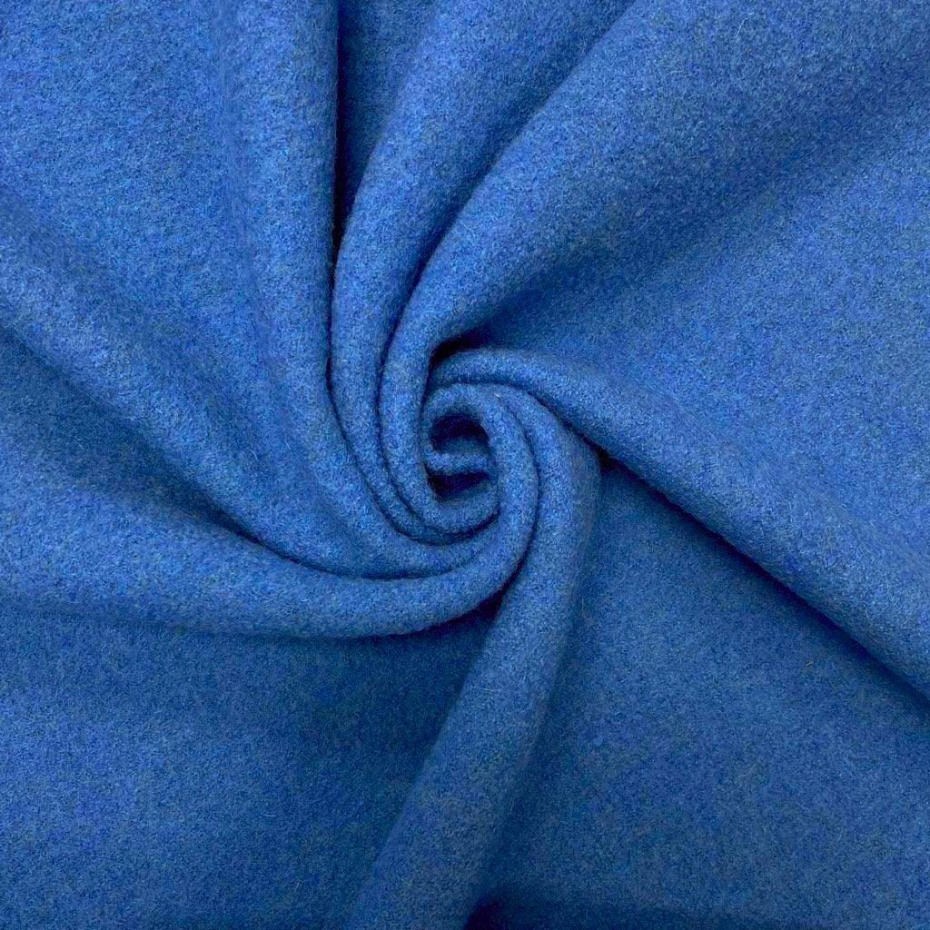 A close-up view of a soft, royal blue fabric twisted into a gentle spiral fold with rich texture and subtle shading.