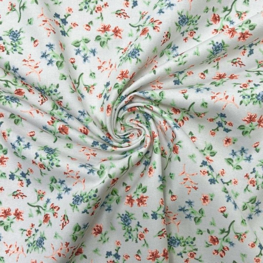A close-up of light-colored fabric with a small floral print. The white/cream background is scattered with tiny red, blue, and green flowers and leaves, arranged in a delicate, ditsy pattern.