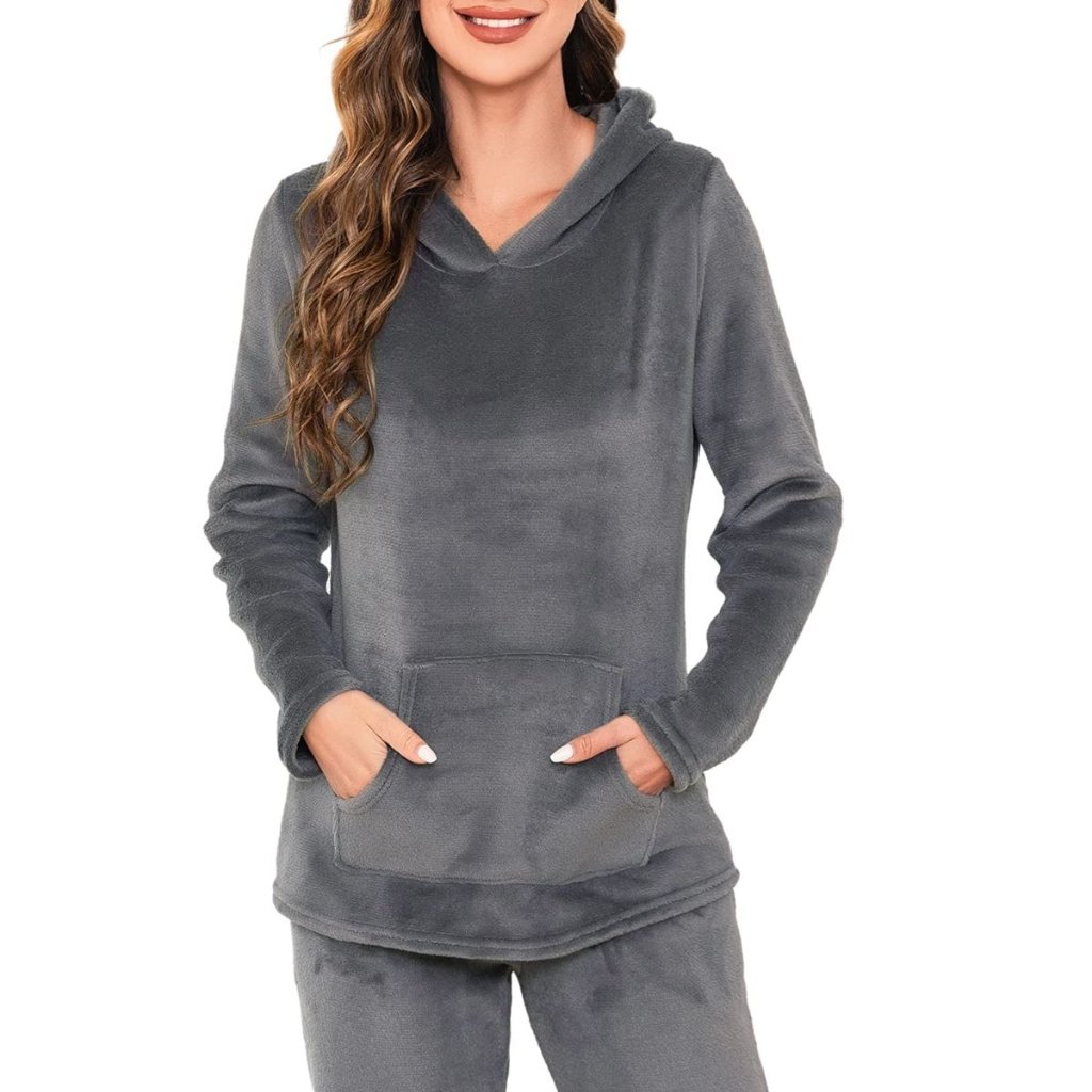A woman wearing a charcoal gray fleece hoodie with a front pocket and matching gray fleece pants. She has her hands in the pocket of the hoodie.