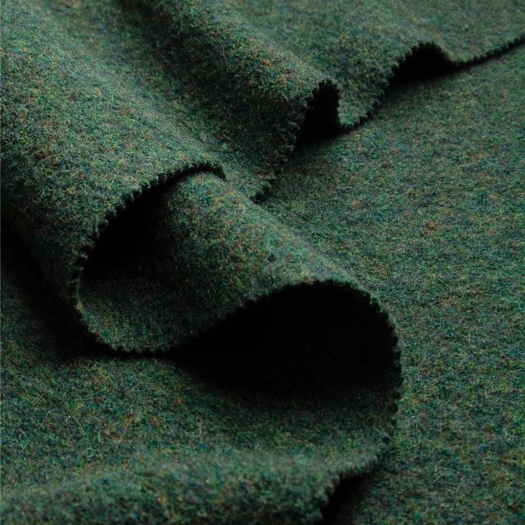 Close-up of dark green felt or wool fabric with a soft, fuzzy texture and curled folds.