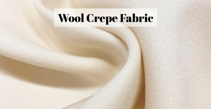 Close-up of soft, cream-colored wool crepe fabric with a folded edge.