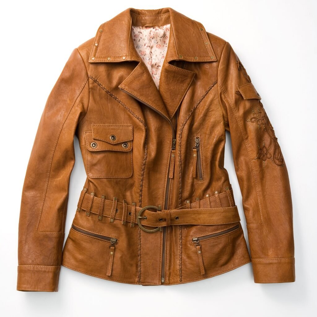 A tan/brown leather motorcycle jacket with multiple zippers, belt, and stitched detailing. It has a floral lining peeking from the collar, a front zipper, zippered pockets, and decorative stitching along the sleeves.Urban Field Leather Jacket ,