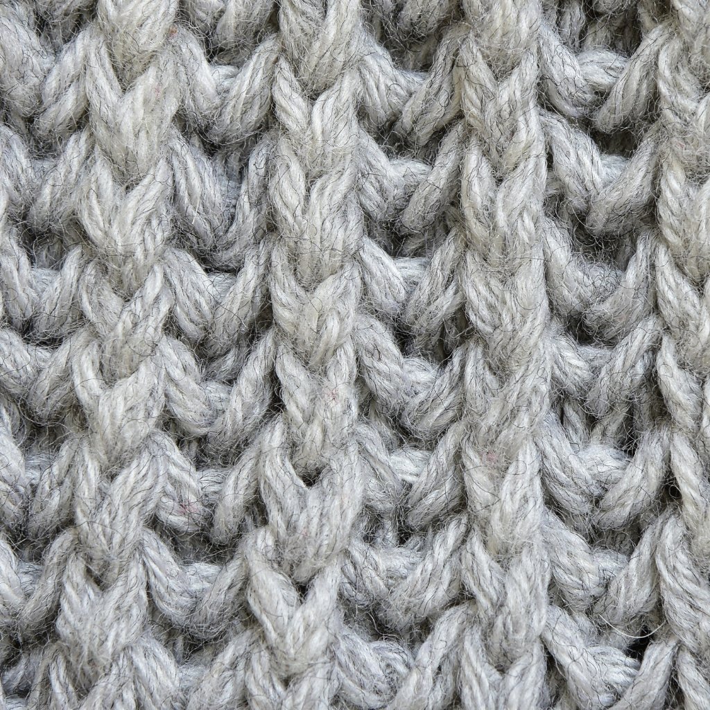 Close-up view of thick, gray, twisted knitting yarns interwoven in a chunky textile pattern. Elasticity and Shape Retention