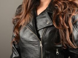 Close-up of a black leather moto biker jacket with silver zippers and a folded lapel.