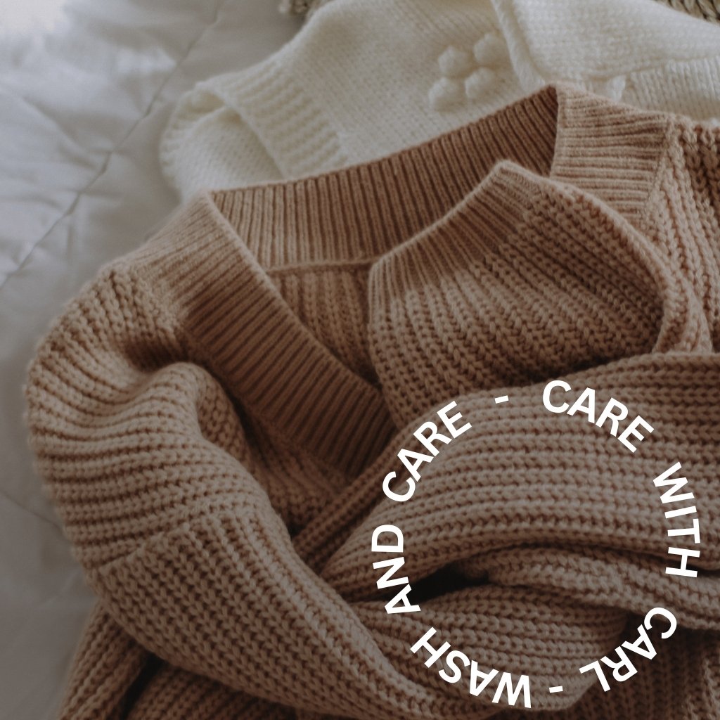A soft, knit sweater in warm beige draped over fabric, with white circular text reading “CARE WITH CARE - WASH AND CARE” arranged in a ring across the front.
