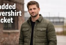 The Ultimate Padded Overshirt Jacket for Modern Layering A man wearing an olive padded overshirt jacket standing outdoors near a brick building.