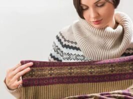 Woman examining the fabric of a patterned wool sweater, checking its texture and quality.Does Shetland Wool Itch?
