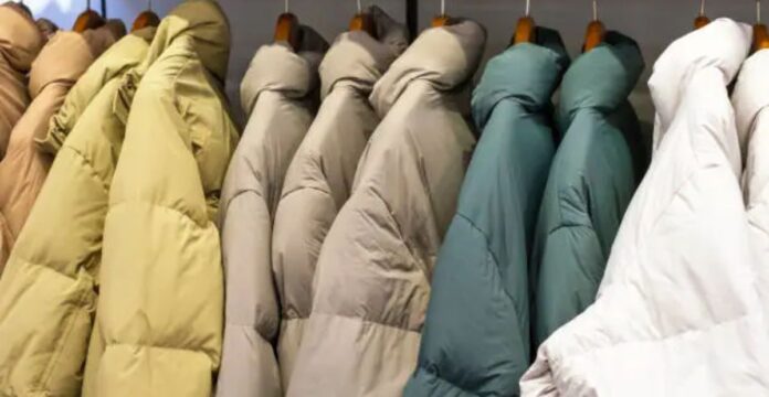 Close-up of a person wearing a red quilted jacket with one hand tucked into the pocket.Why Oversized Padded Jackets