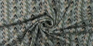 Is Herringbone Wool Worth It? Pros, Uses, and Styling Tips Close-up of patterned shell fabric with a textured weave in muted green, beige, and black tones, arranged in a swirl.Is Herringbone Wool Worth It?