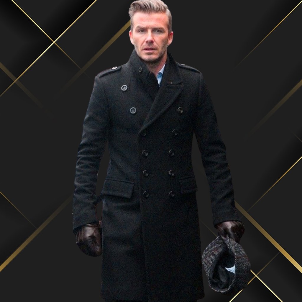 A man wearing a long black double-breasted coat and brown gloves, holding a checkered hat, standing against a dark geometric backdrop with gold lines.