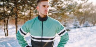 Track Jacket for Men: The Ultimate Style & Performance Guide A man stands outdoors in a snowy park wearing a mint green and black windbreaker with white and black stripes across the chest and arms. Track Jacket for Men