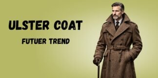 Ulster Coat Guide: History Features and Styling Tips Ulster coat model in a long brown wool trench with a belt and cane, against a light olive background.