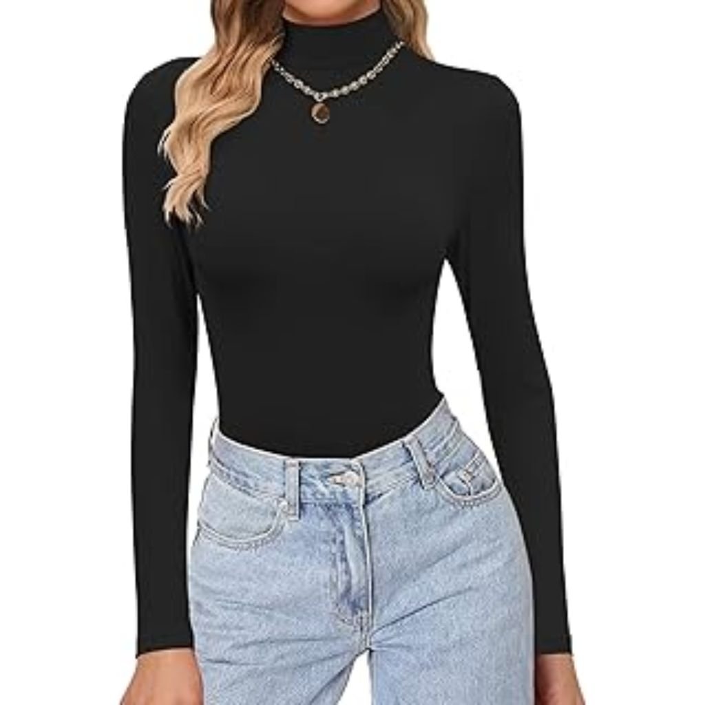 A woman posing with one hand raised over her head, wearing a dark sleeveless knit top layered over a houndstooth-patterned blouse, standing against a light background.Why Mock neck turtlenecks