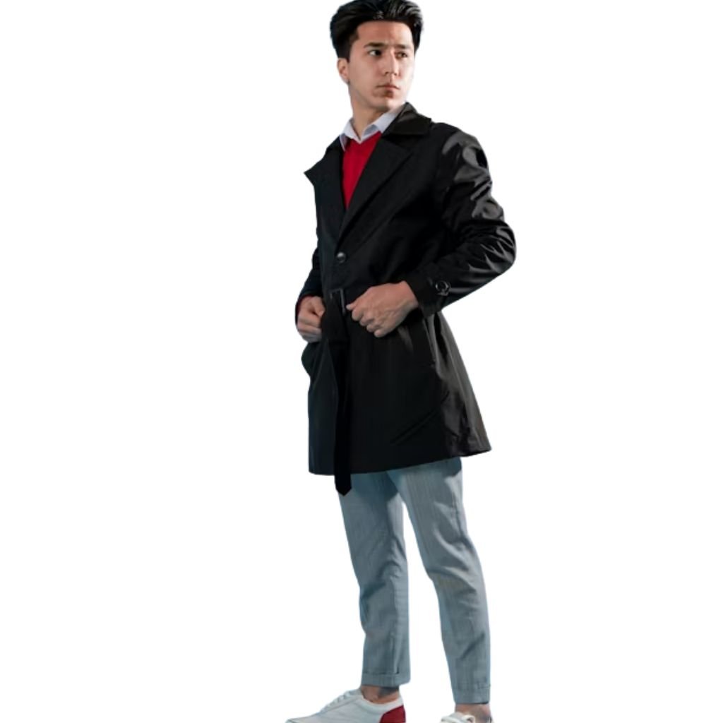 A man wearing a black coat over a red sweater and white shirt stands against a white background, looking to the side.Trench-Style Winter Coats