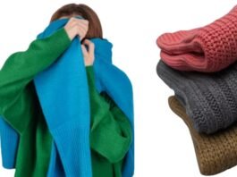 A person in a green sweater playfully covering their face with a bright blue knitted scarf, alongside a neatly folded stack of cozy knitwear in pink, gray, and brown, illustrating warmth, comfort, and the question “does polyester make you sweat.”cozy winter outfits