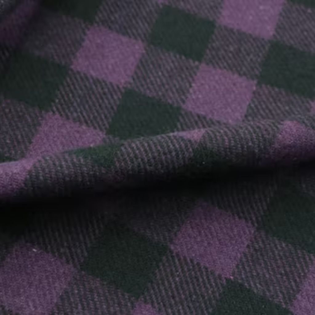 Close-up of a soft wool fabric featuring a purple and dark green checkered pattern with a subtle diagonal weave texture.Does Shetland Wool Itch?