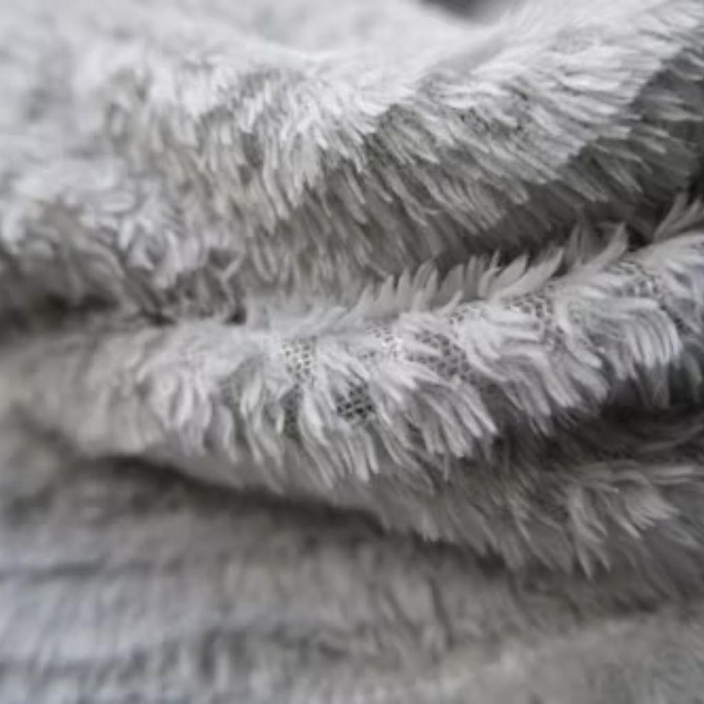 Close-up of soft gray plush fabric with a dense, fluffy texture and layered folds.Is Herringbone Wool Worth It?
