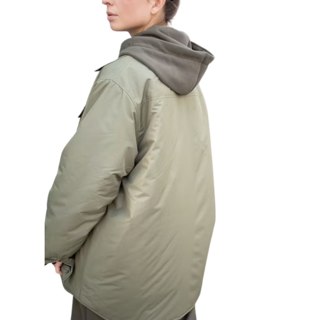 A person wearing an oversized light-olive padded jacket layered over a dark hoodie, shown from the back against a white background.Why Oversized Padded Jackets