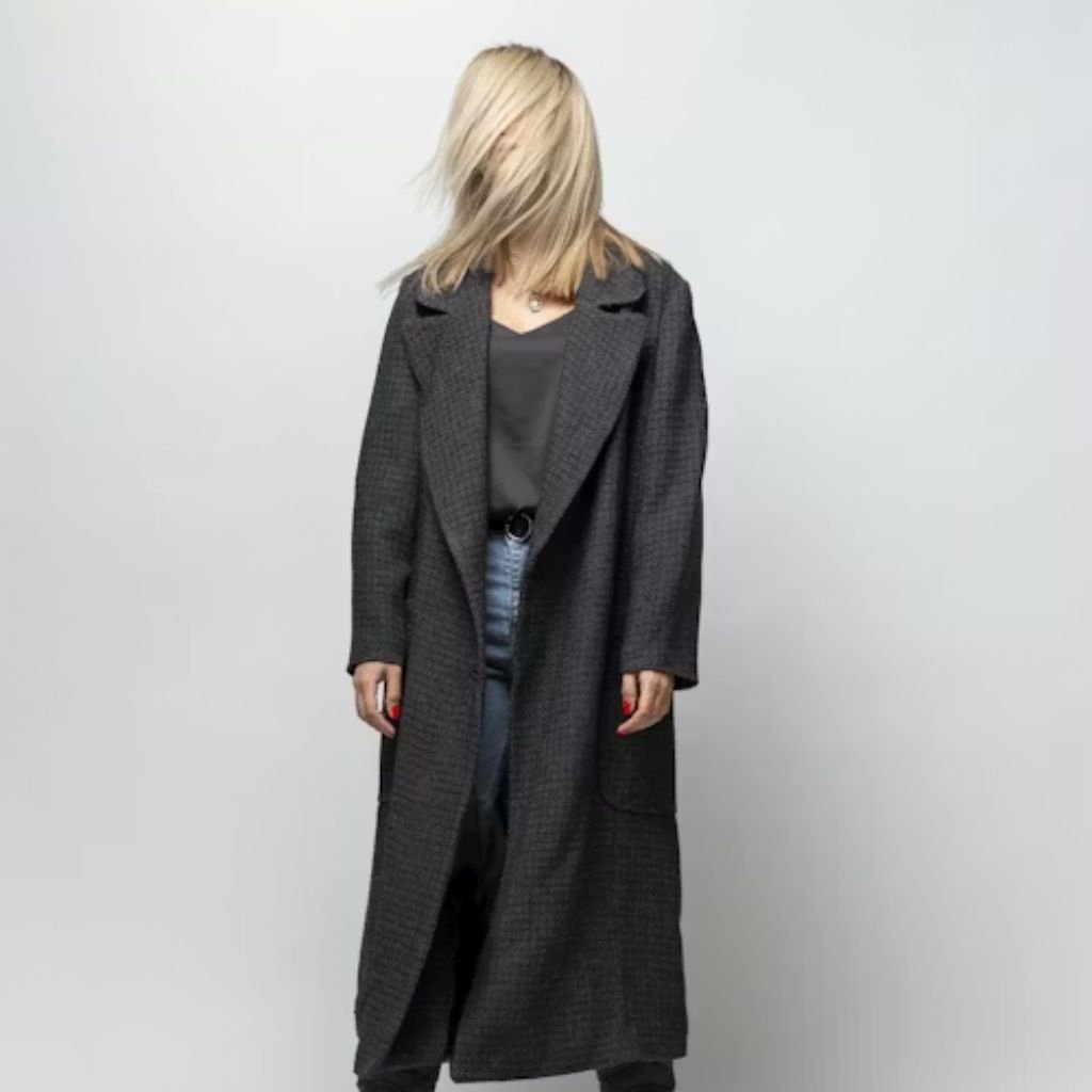 Close-up of a light beige double-breasted coat with dark buttons and a hand in the pocket.Is a Long Parka Coat Worth It?