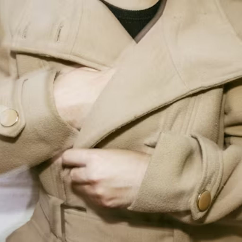 Close-up of a person’s hands buttoning a dark suit jacket, with a wristwatch visible.Double-Breasted Wool Jackets: