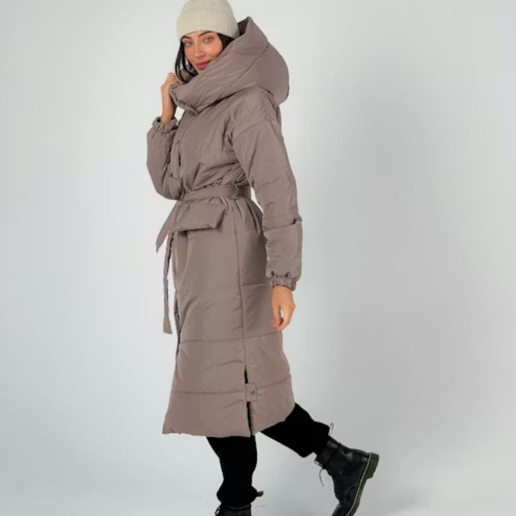 Man wearing a beige trench coat and black scarf standing on a city street, looking to the side.Trench-Style Winter Coats