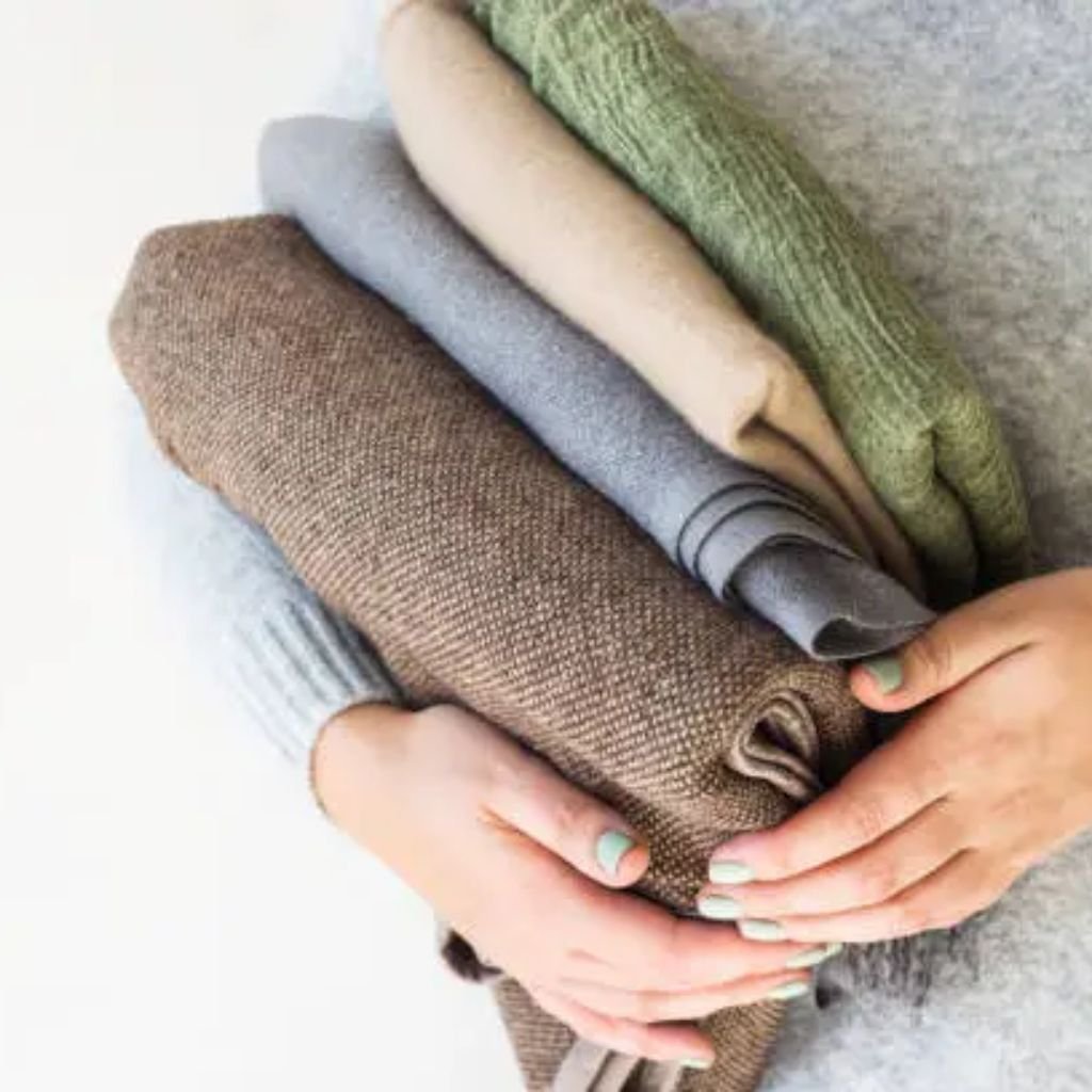 Man wearing a dark brown zip-up knit sweater with a ribbed collar, cuffs, and hem, styled casually over trousers.Does Shetland Wool Itch?