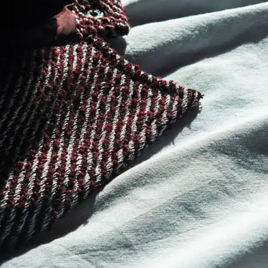 Close-up view of beige herringbone wool fabric with a classic zigzag weave pattern.Is Herringbone Wool Worth It?