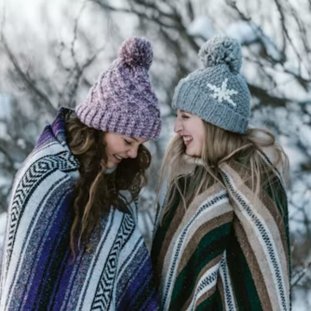 A woman walking on snow-covered railway tracks wearing a cozy winter outfit with a large green plaid scarf, white sweater, black skirt, tights, and boots.Monochrome winter outfits