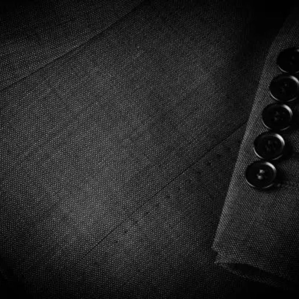 Close-up of dark textured fabric with visible weave and soft folds.Is Herringbone Wool Worth It?