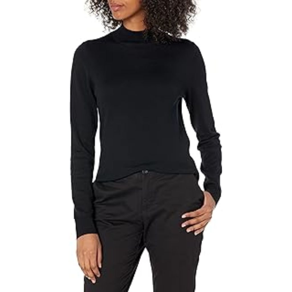 A woman wearing a light gray oversized mock-neck sweatshirt paired with black pants, posing with one hand tucked into the hem of the sweatshirt.Why Mock neck turtlenecks