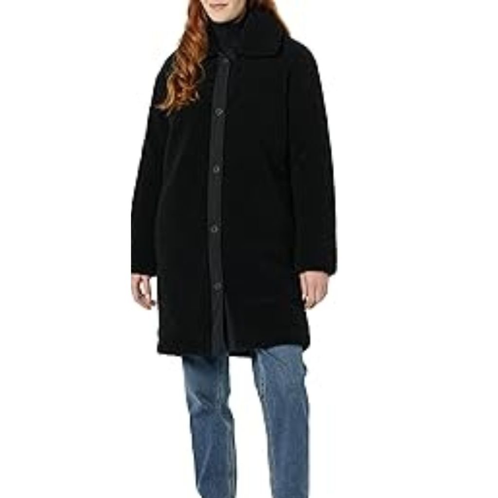 A woman wearing a brown double-breasted wool coat with a wide collar, styled with patterned black leggings.Teddy Coats