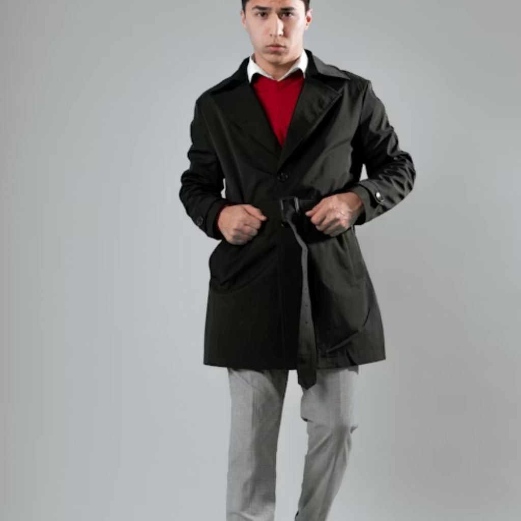 Man wearing a black belted winter coat layered over a red sweater and white shirt, paired with grey trousers, standing against a neutral background.Belted Winter Coats