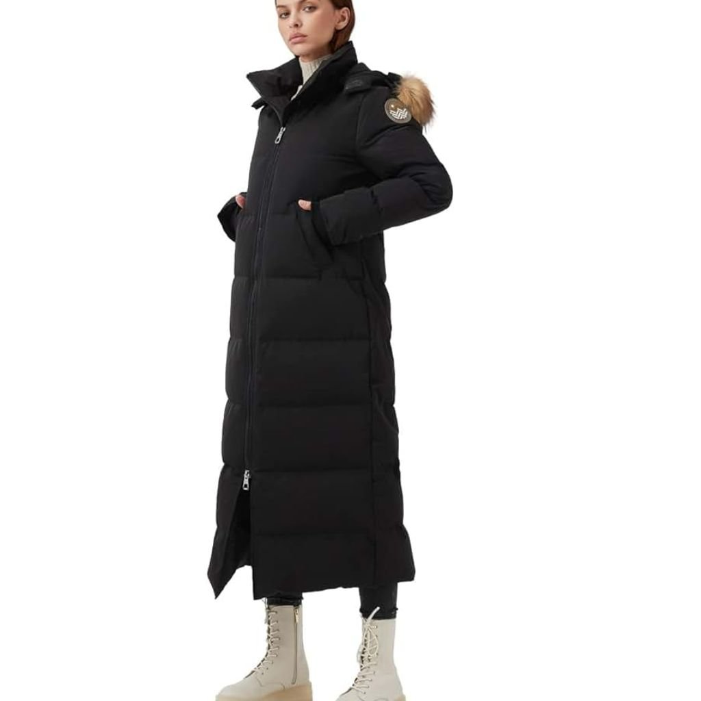 A stylish woman wearing a black long coat, white turtleneck sweater, ripped blue jeans, and a beige quilted shoulder bag with a chain strap.Why Victorian-Era Winter Coats