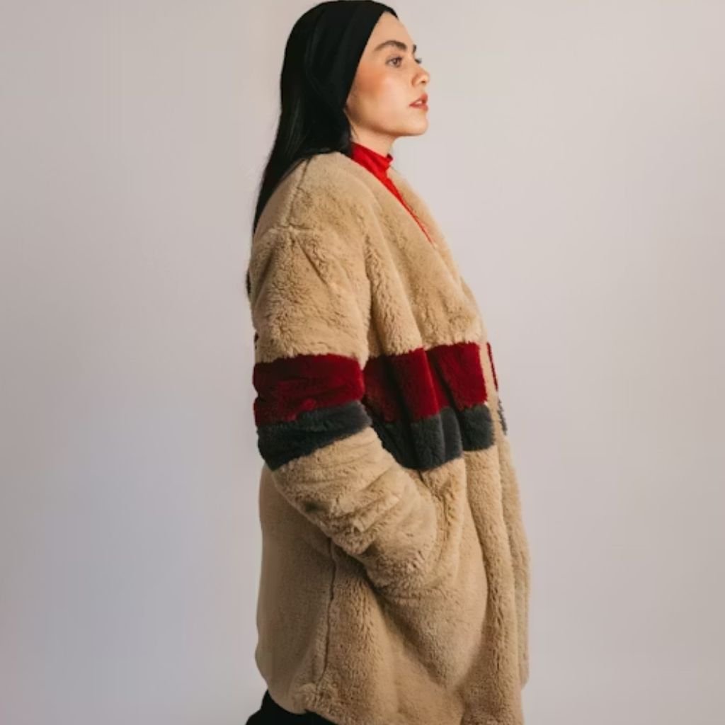 Woman wearing a beige plush winter coat with red and dark stripe accents, shown in side profile against a neutral background.Is Pure Wool Worth It?