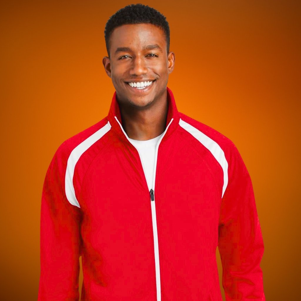 A smiling man wearing a red zip-up jacket with white stripes on the shoulders stands against an orange gradient background.