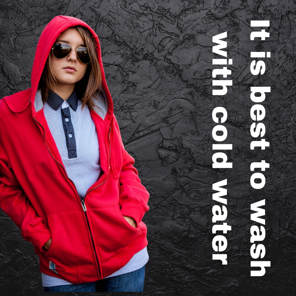 A young person wearing a bright red hoodie and sunglasses stands against a dark, textured wall. Vertical white text along the right reads, “It is best to wash with cold water.” Hoodie Jacket