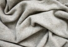 Cashmere Wool Fabric Explained: Benefits, Uses, and Care Soft beige cashmere wool fabric with a smooth knitted texture, gently draped to highlight its fine weave and natural warmth.
