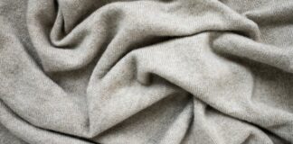 Cashmere Wool Fabric Explained: Benefits, Uses, and Care Soft beige cashmere wool fabric with a smooth knitted texture, gently draped to highlight its fine weave and natural warmth.