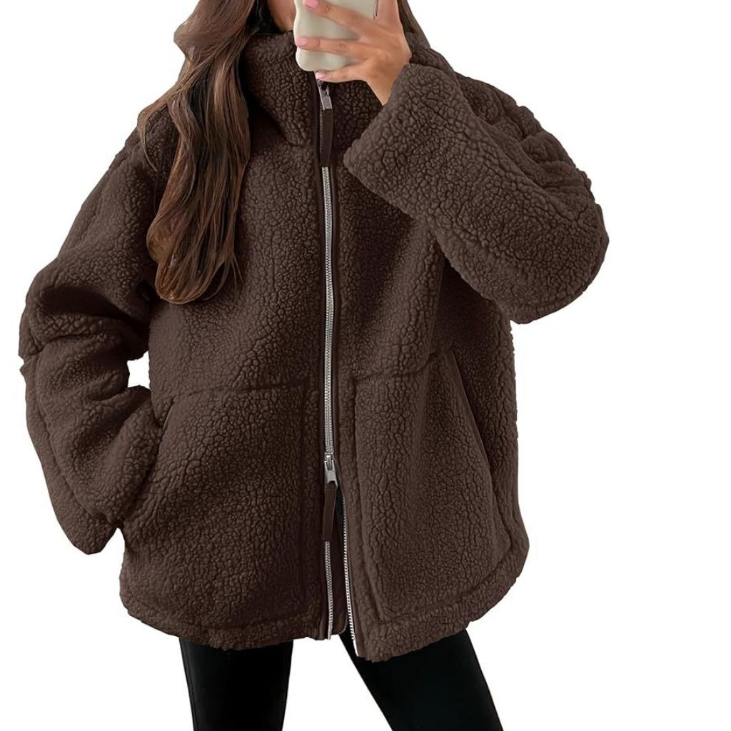 “A person wearing a oversized brown sherpa jacket with a full front zipper and large pockets.”
