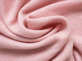 Grade B Cashmere Wool Fabric Close-up of soft pink knit fabric with folds and gentle texture.Grade B Cashmere Wool Fabric