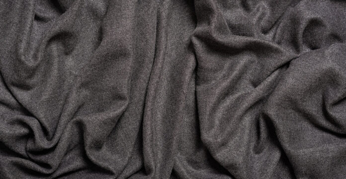 Grade C Cashmere Wool FabricA close-up of dark gray fabric with soft folds and texture.