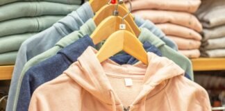 Stylish Hoodie Jacket: Comfort, Warmth, and Everyday Wear A rack of pastel-colored hoodies on wooden hangers in a store, with soft beige, pink, blue, and green jackets.
