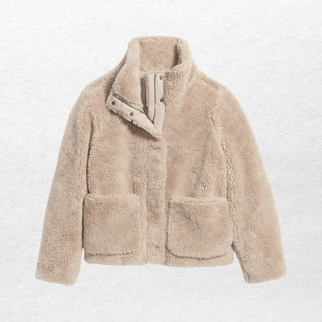  A cozy, cream-colored sherpa jacket with a high collar and two large front pockets, made from soft, fluffy fleece.