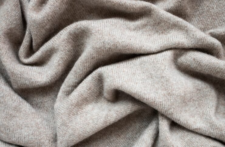 Knitted Grade A Cashmere Wool Fabric Close-up of soft, light gray fabric with gentle folds and a textured knit.