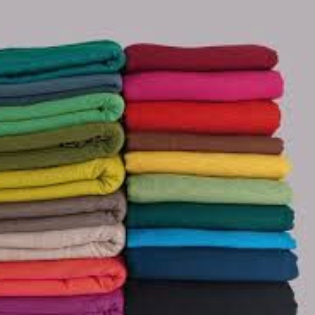 Soft Winter Fabrics for Sensitive Skin: Cozy & Itch-Free Now 7 A tall stack of folded, colorful sweaters arranged by color from turquoise at the top to black at the bottom.
Soft Winter Fabrics for Sensitive Skin: