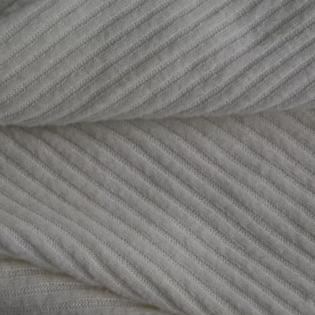 Alt text: “Close-up of light gray ribbed knit fabric with diagonal ridges, folded over itself.”

Vegan Winter Fabric Explained:
