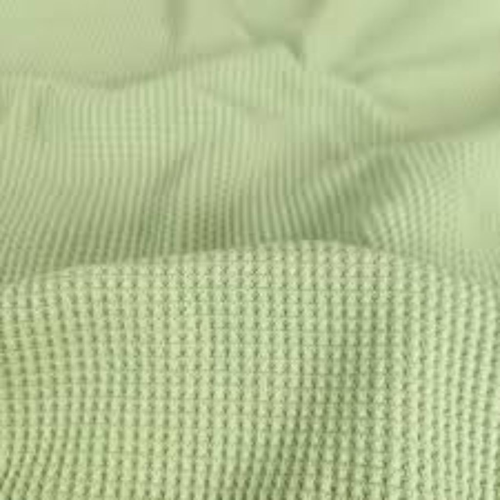 What Is Thermal Fabric? Features, Uses, and Buying Tips 11 Macro close-up of light green ribbed fabric with fine vertical lines and soft folds.”What Is Thermal Fabric?