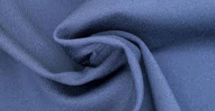 A close-up view of a soft blue fabric folded and twisted to show its texture and drape. Moisture-Wicking Winter Fabric Explained: